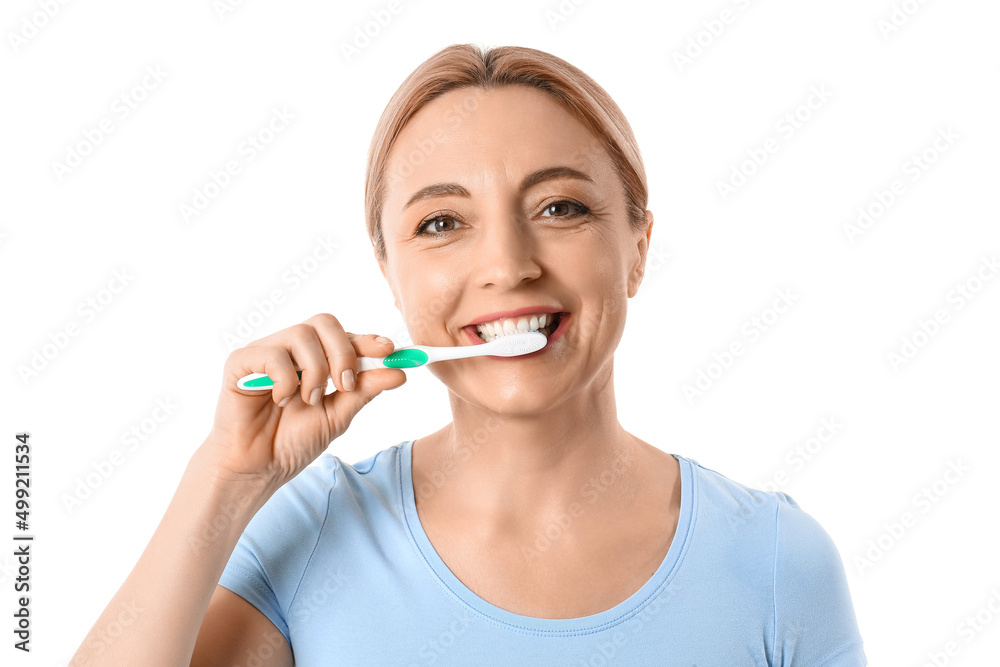 Beautiful mature woman brushing teeth on white background