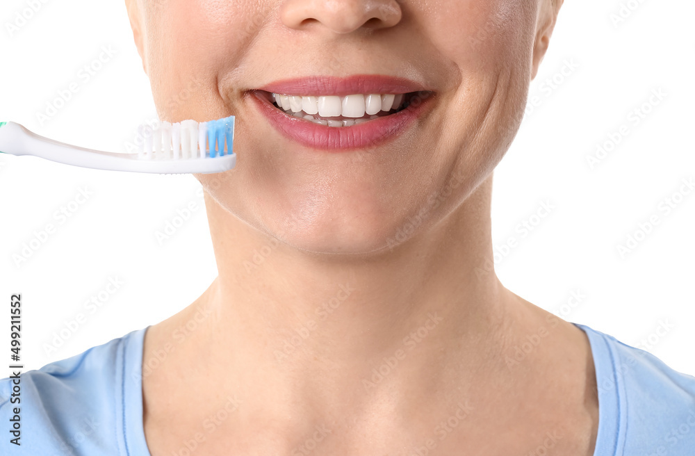 Beautiful mature woman brushing teeth on white background, closeup