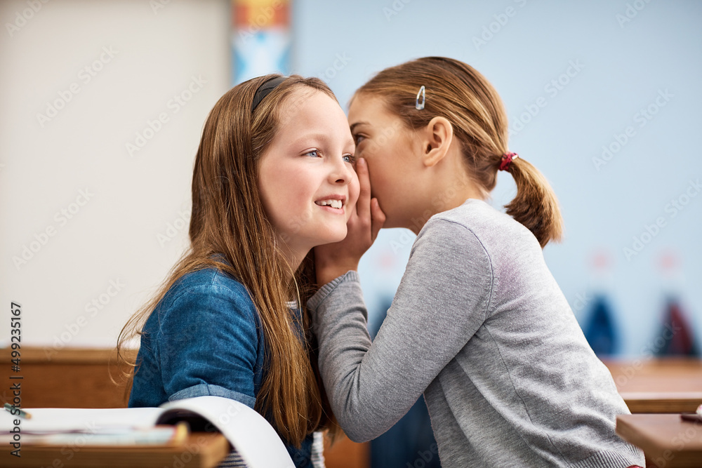 Promise you wont tell anyone.... Shot of an elementary school girl whispering in her friends ear in 