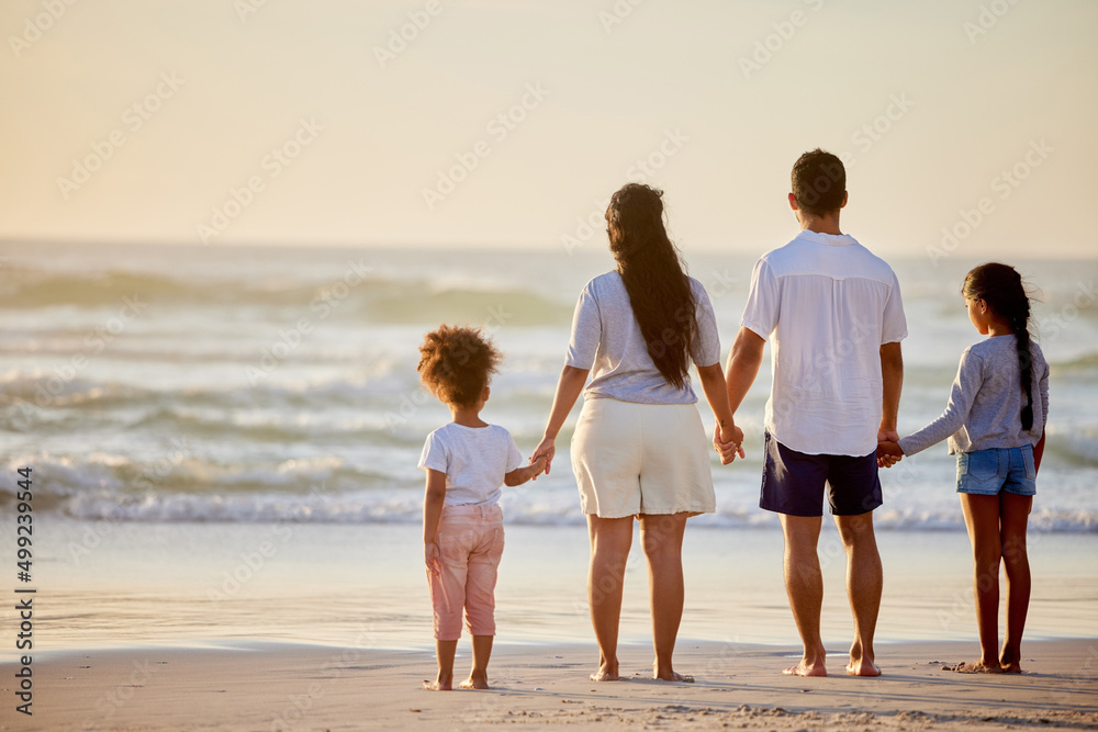 A happy family is but an earlier heaven. Shot of a family watching the sunset at the beach.