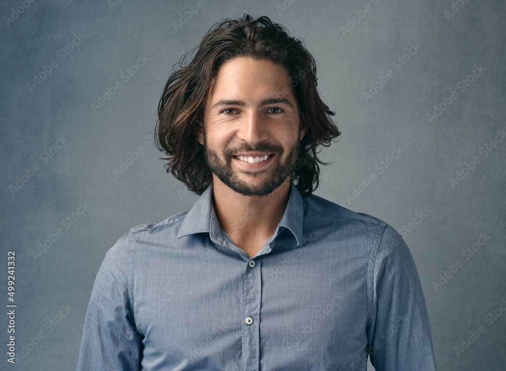 Whats there not to like. Cropped shot of a handsome young man posing against a grey background.