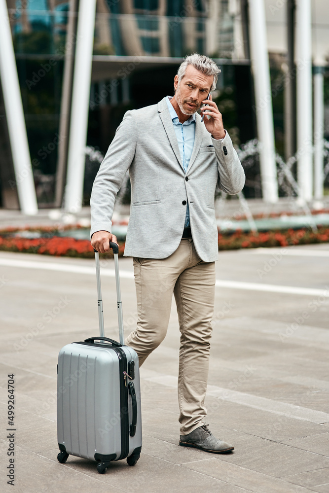 Hes ready to take on the city. Shot of a mature businessman talking on a cellphone while walking wit