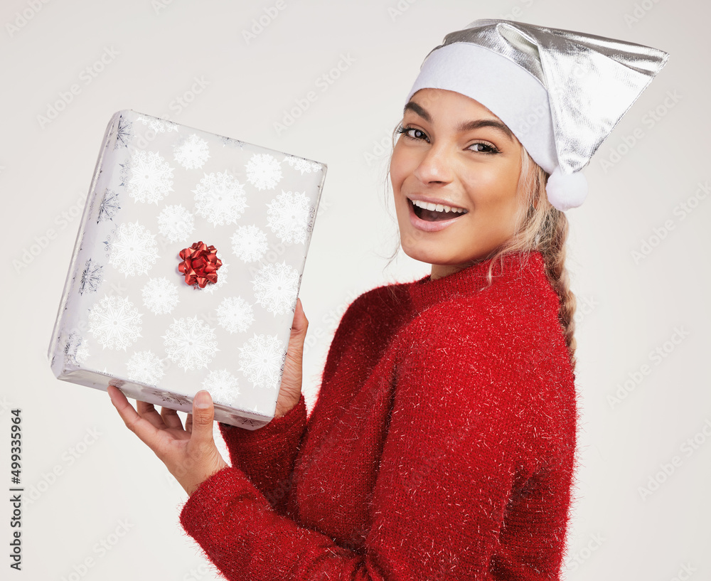 I always like the gifts I get. Studio shot of a young woman holding a gift box against a grey backgr