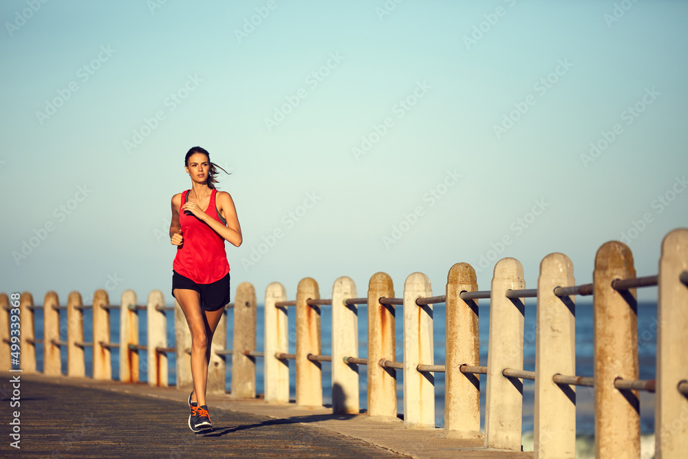 Keep up the pace or youll fall behind on your goals. Shot of a sporty young woman exercising outdoor