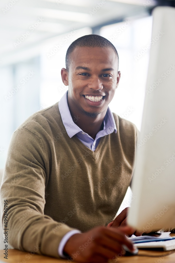 The work I do keeps me smiling. Portrait of a handsome young businessman working in his office.