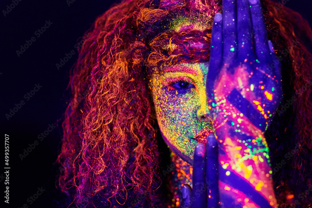 You cant block out true colour. Cropped portrait of a young woman posing with neon paint on her face