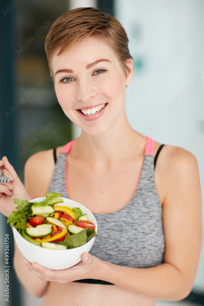 健康是我做出的最好决定。一个健康的年轻女人吃一碗沙拉的画像。