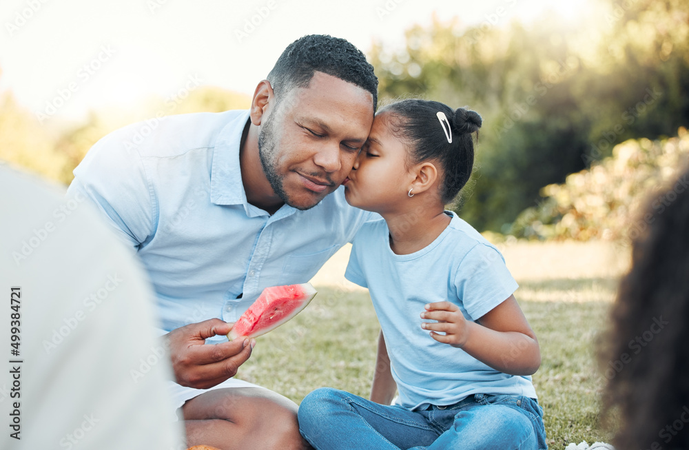 Call it a tribe, call it a family. Shot of a daughter kissing her dad at a picnic.