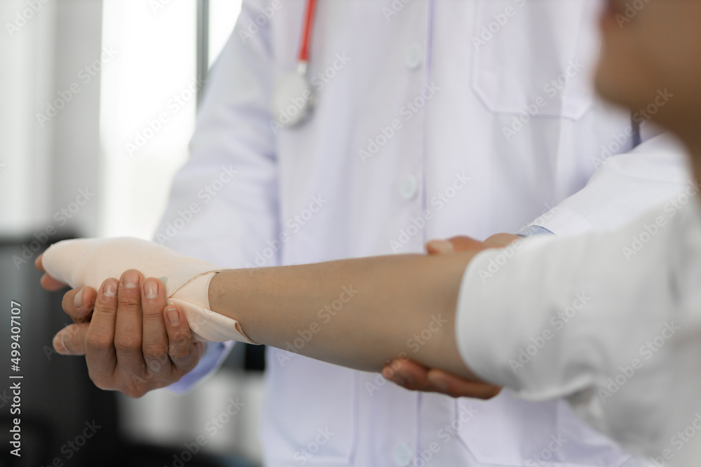 Physical therapy. First aid and wrist injury treatment. Doctor wrapped around the wrist for first ai