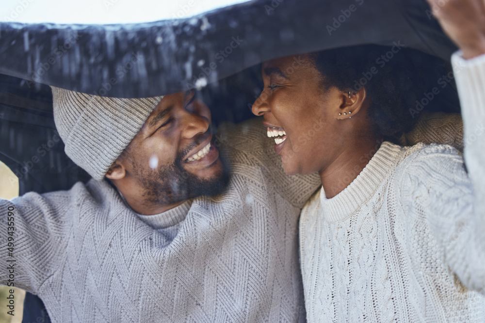 Baby its cold outside. Shot of a young couple protecting themselves from the rain.