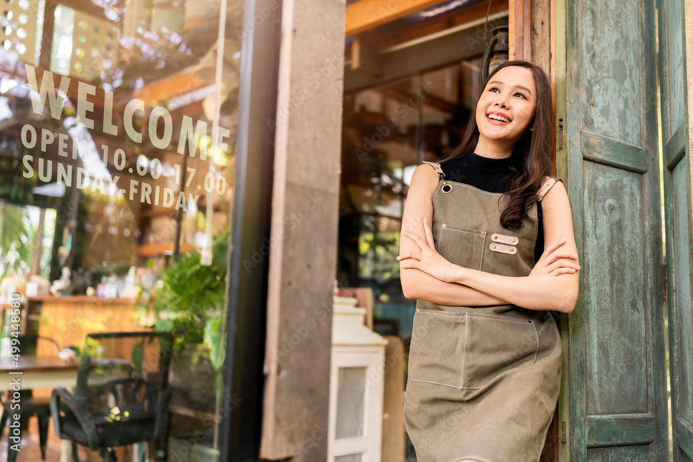 portrait of asian adult female woman wear apron standing at entrance of her workshop pottery studio 