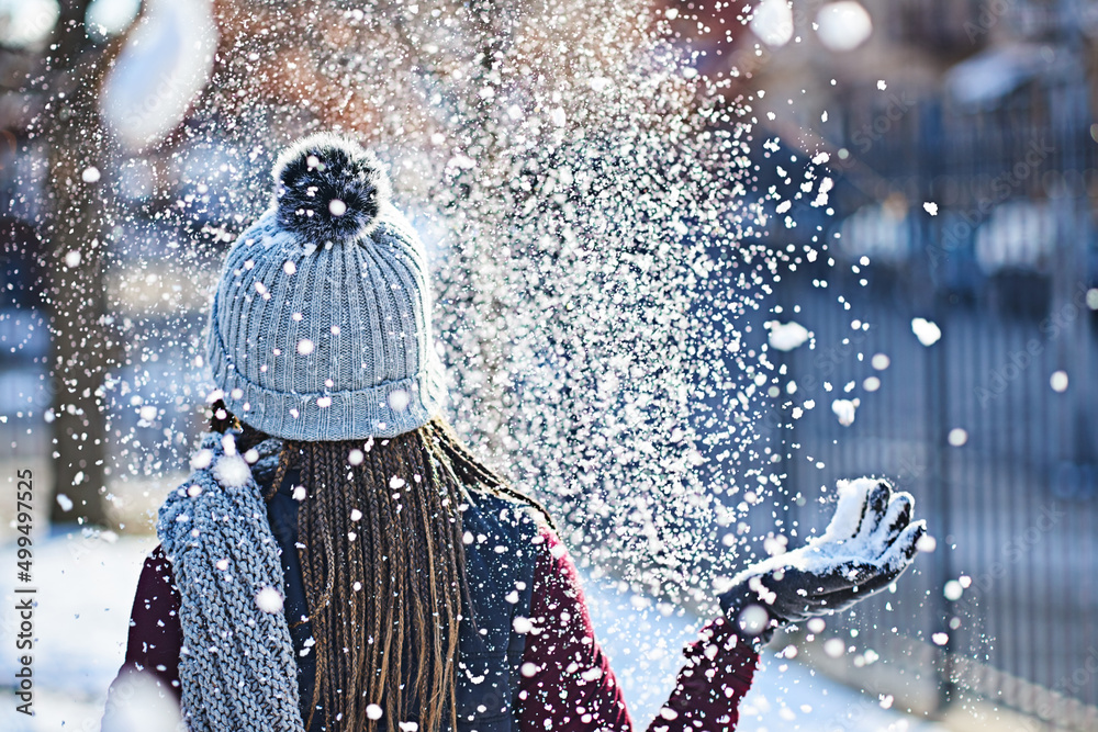 她把雪变成了闪光的东西。一个年轻女子在冬天的户外扔雪的后视镜头。