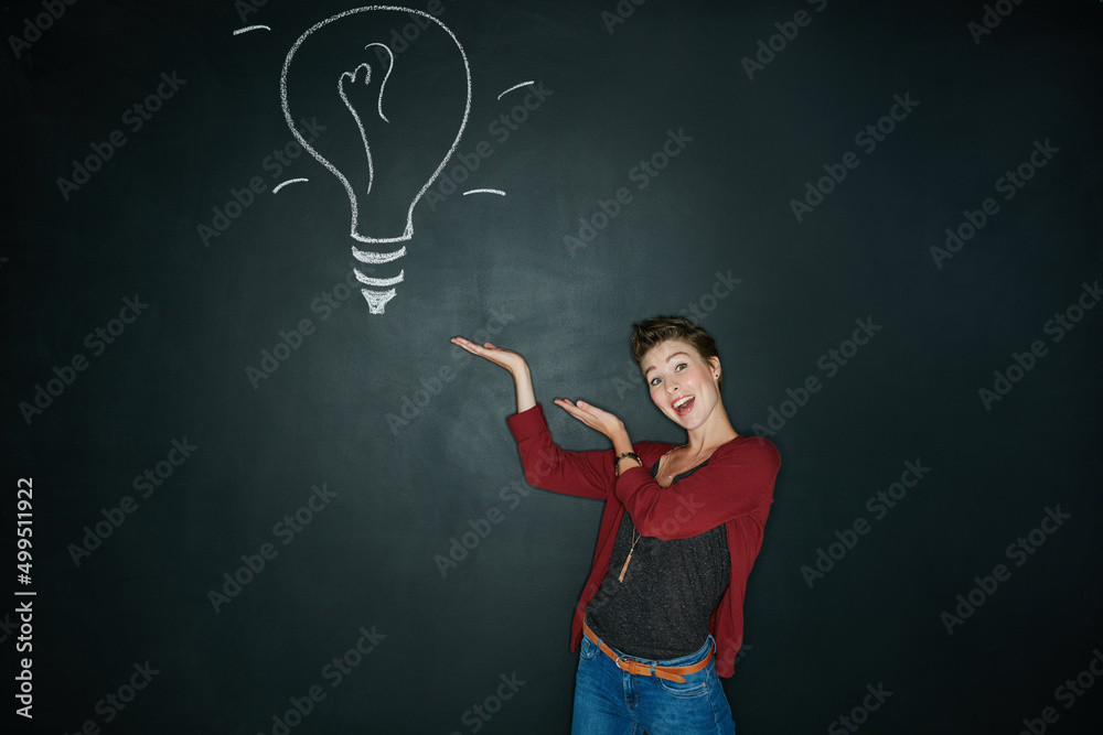 Presenting the solution to your problem. Studio shot of a young woman posing with a chalk illustrati