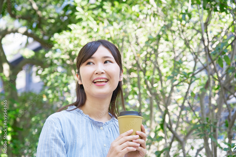 女性　コーヒーを飲む　屋外