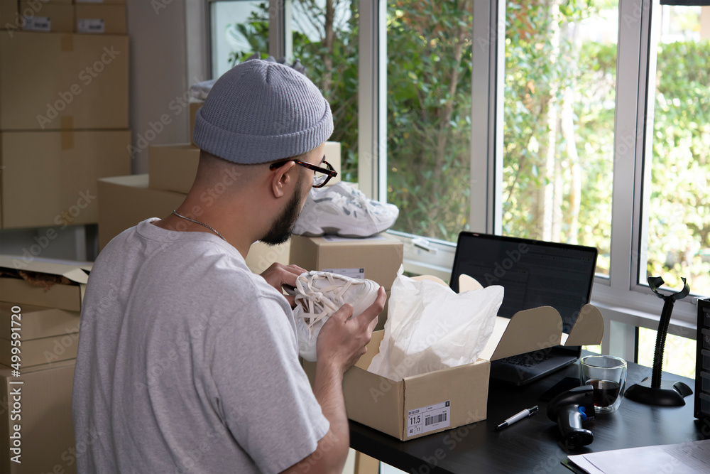 Asian man business owner working, packing the order for shipping to customer. Male entrepreneur pack