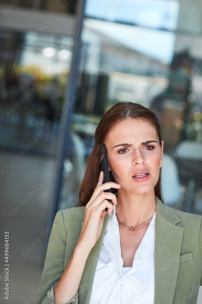 I dont understand...can you explain that again. Shot of a young businesswoman using a mobile phone a