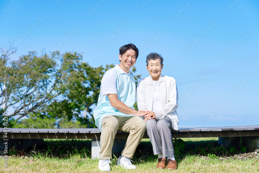 介護士と高齢者　屋外