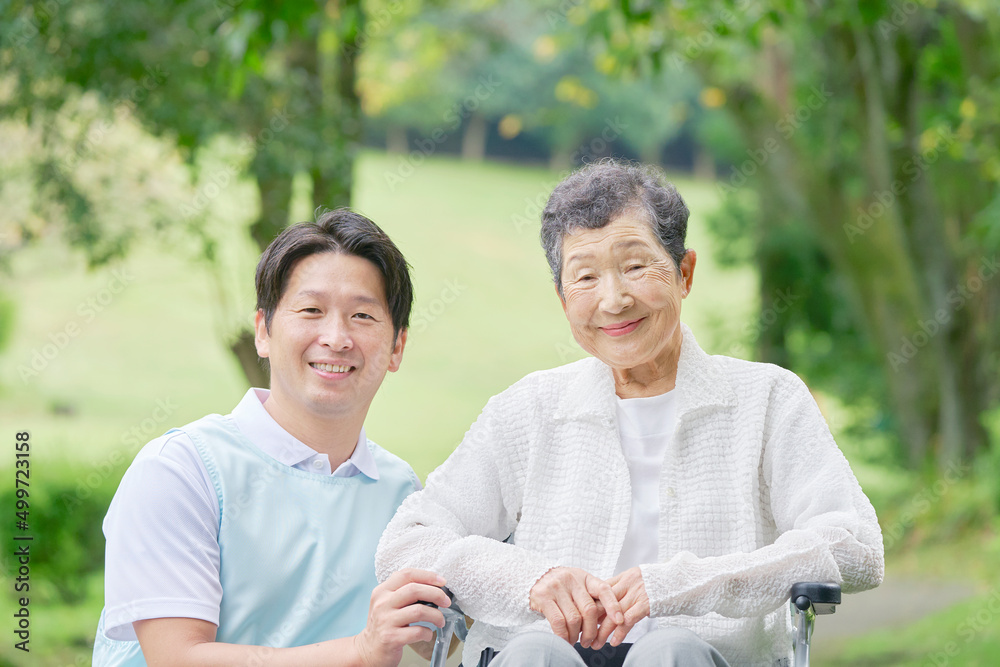 介護士と車椅子に乗った高齢者　屋外ポートレート