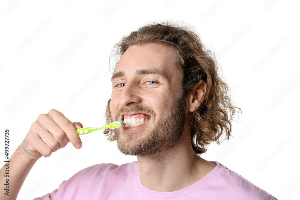 Handsome young man brushing teeth on white background