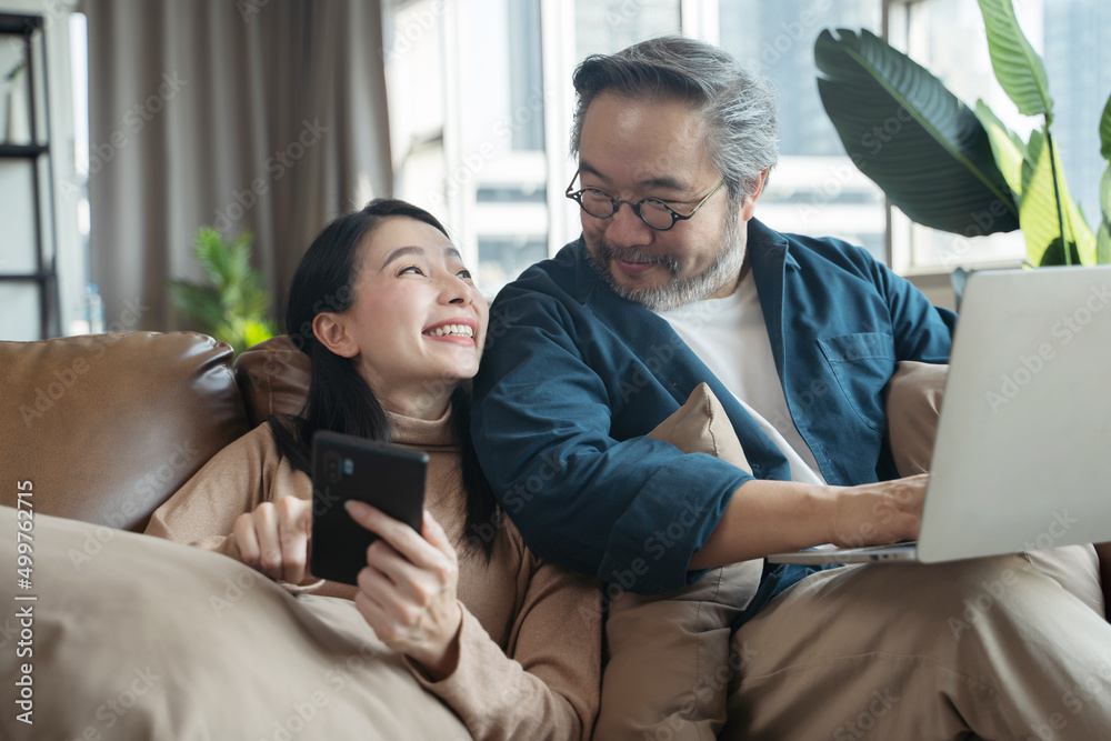 家里客厅里的亚洲中年夫妇