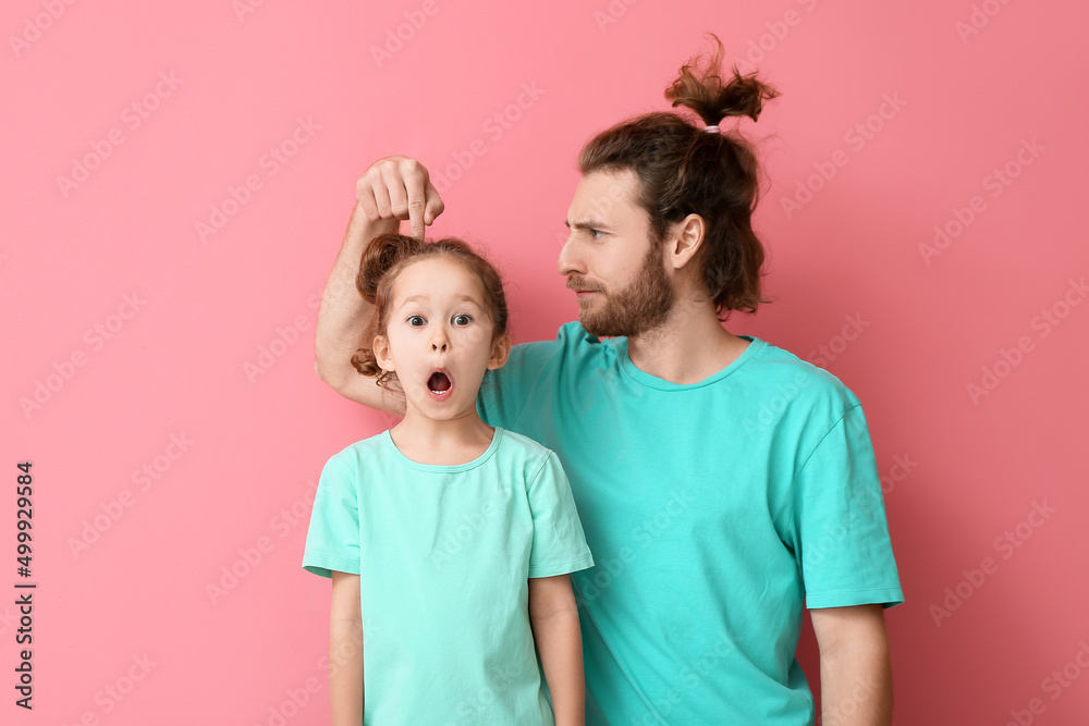 粉色背景的有趣男人和她的小女儿。四月愚人节庆祝活动