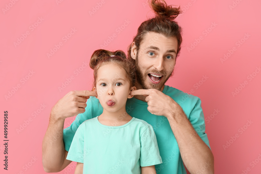 粉色背景下的滑稽男子和她的小女儿。愚人节庆祝活动