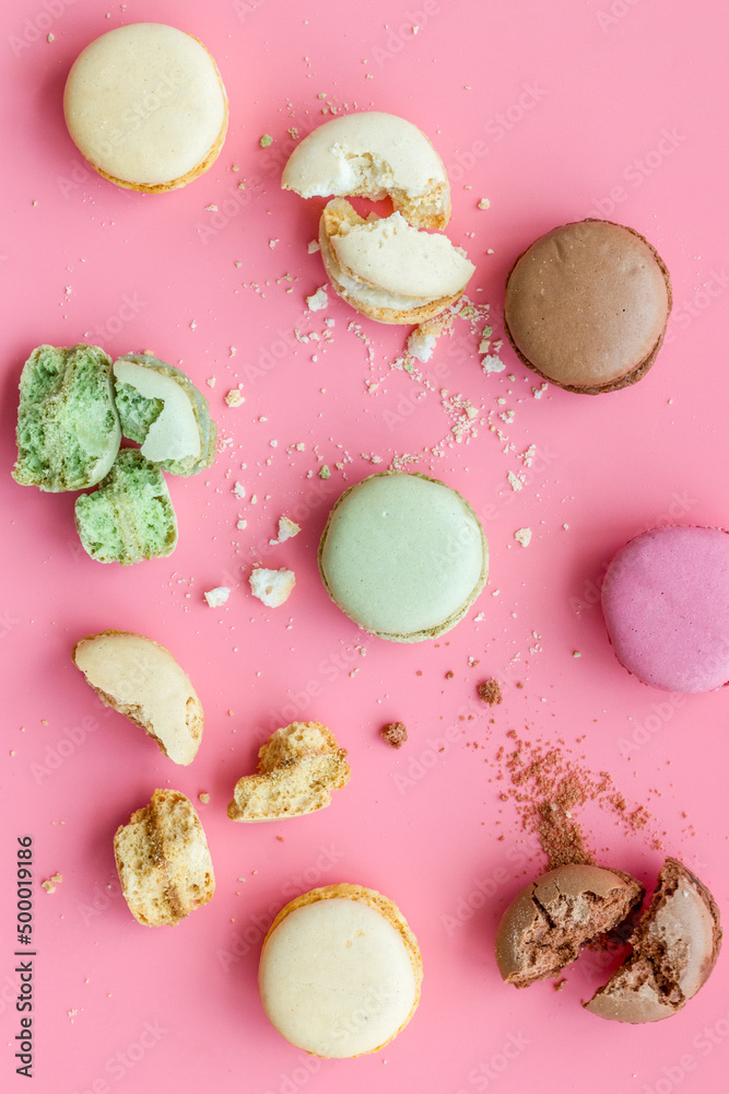 Brignt macarons for sweet break on pink background top view pattern