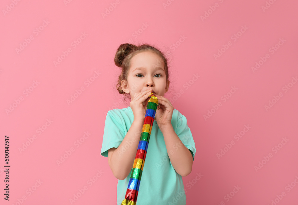 有趣的小女孩，彩色背景上有派对吹风机。愚人节庆祝活动