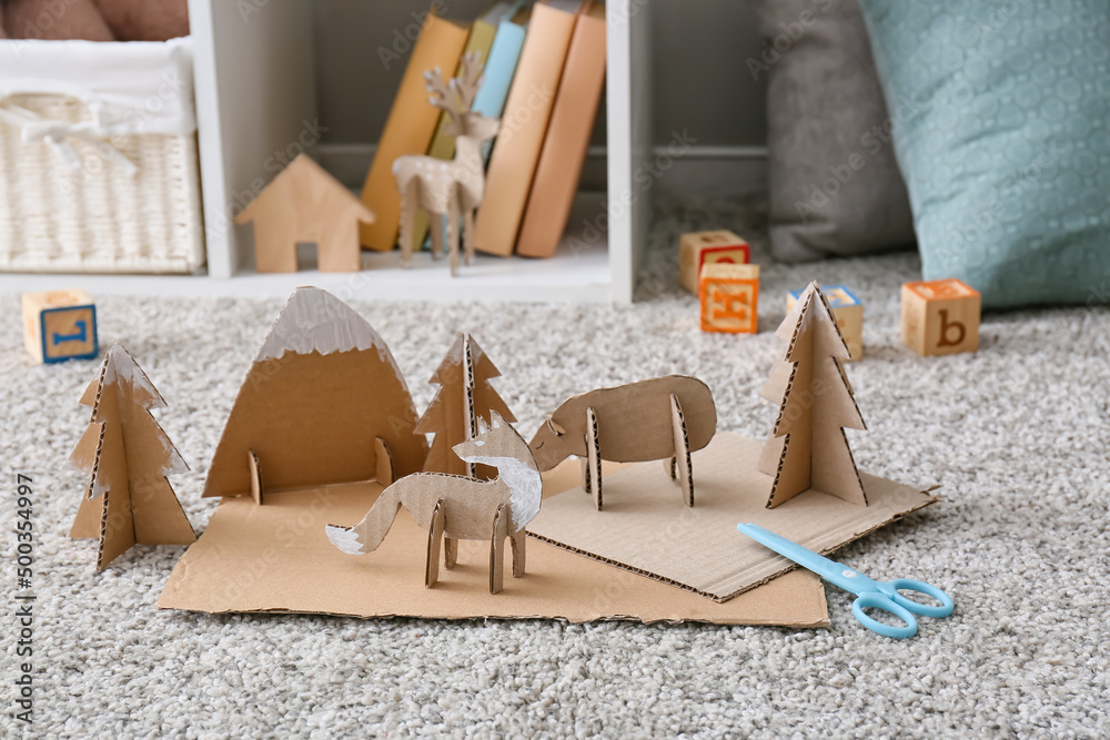 Different handmade cardboard toys on floor in childrens room