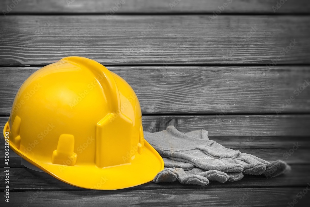 Yellow hardhat and old leather gloves