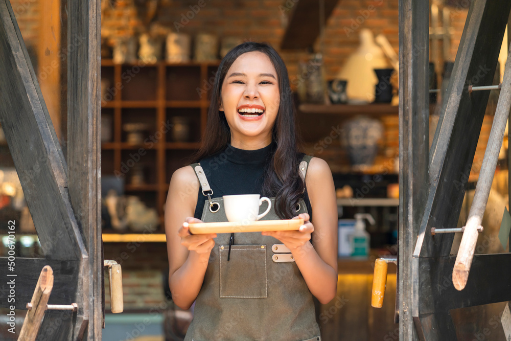 咖啡馆女店主微笑着，带着积极的快乐，准备为顾客开放，亚洲女顾客