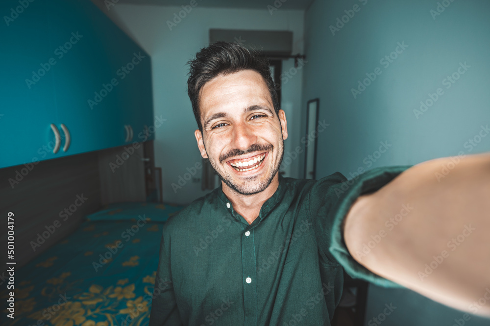 Handsome young man taking selfie at home - Happy guy smiling at camera - Influencer on social media