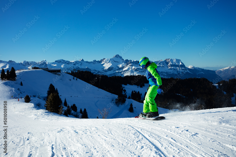 男孩从山上滑下滑雪板