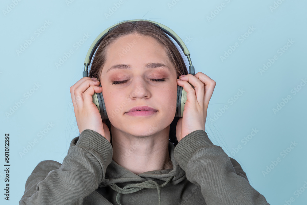 Close up girl portrait with headphones listening music with closed eyes