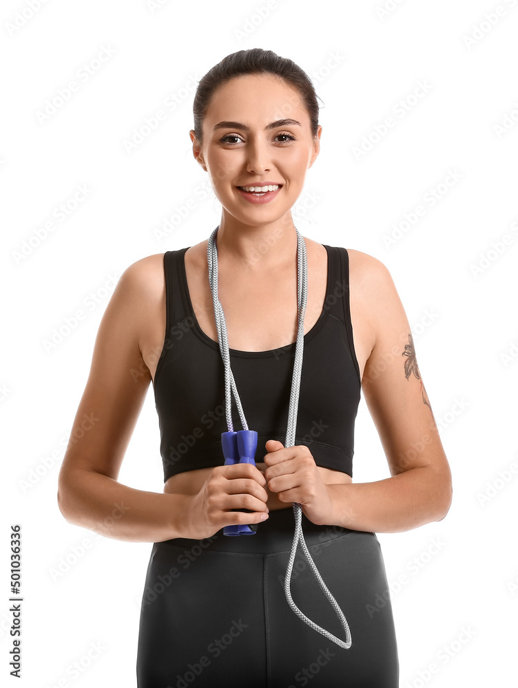 Sporty young woman with skipping rope on white background