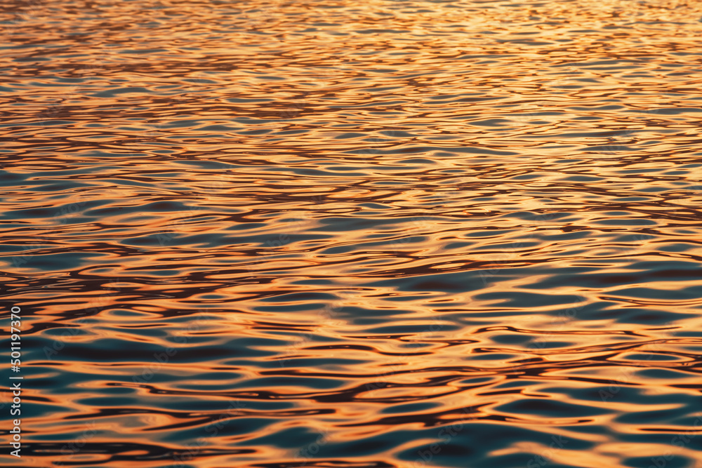 Rippled surface of blue sea water in sunset