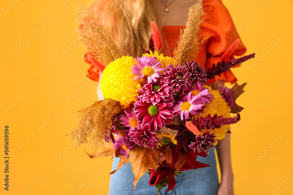 带着黄色背景的美丽秋季花束的女人，特写