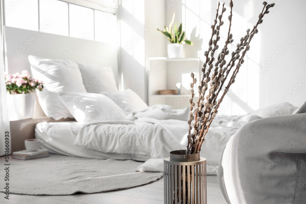 Vase with pussy willow branches in light bedroom