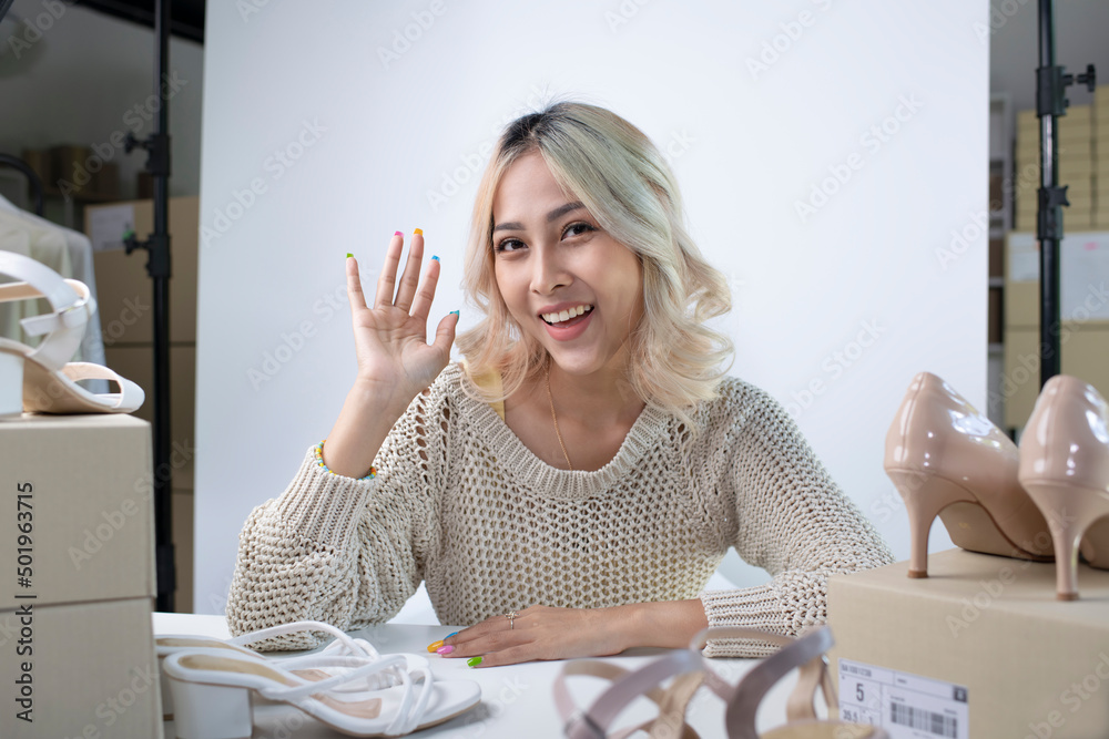 年轻迷人的亚洲女博主或视频记录者看着镜头打招呼。现代商务女性