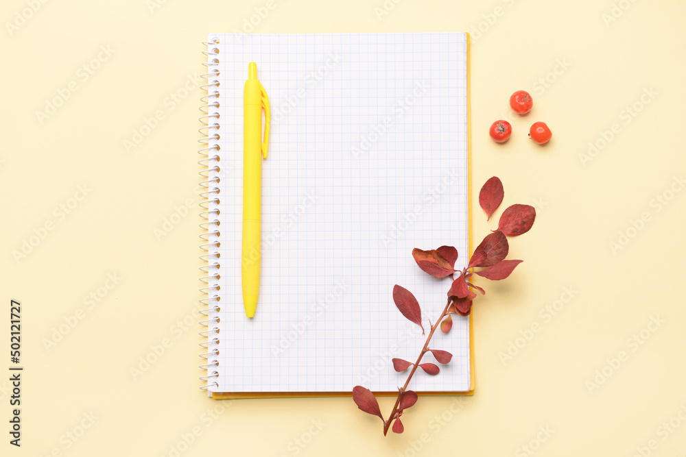 Notebook and pen on yellow background