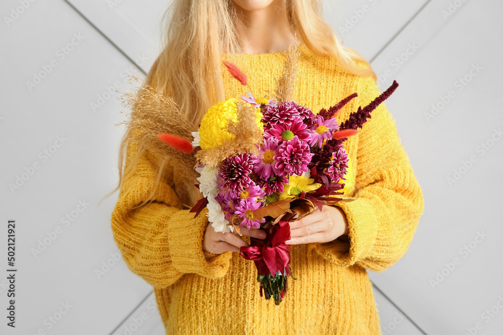 Woman with beautiful autumn bouquet on light background, closeup