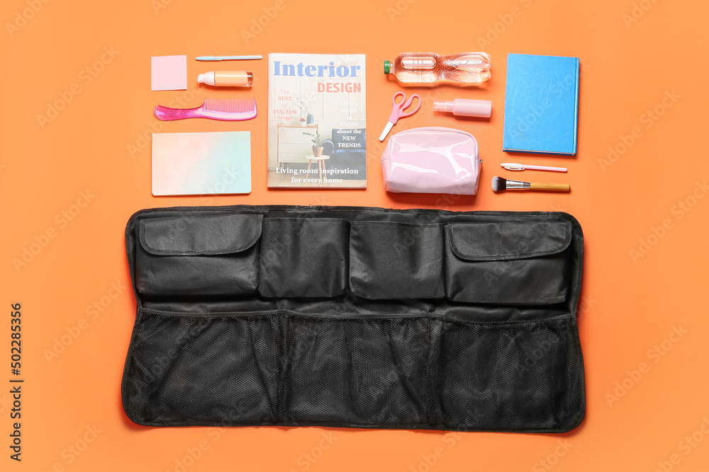 Travel organizer with cosmetics, stationery and bottle of water on color background