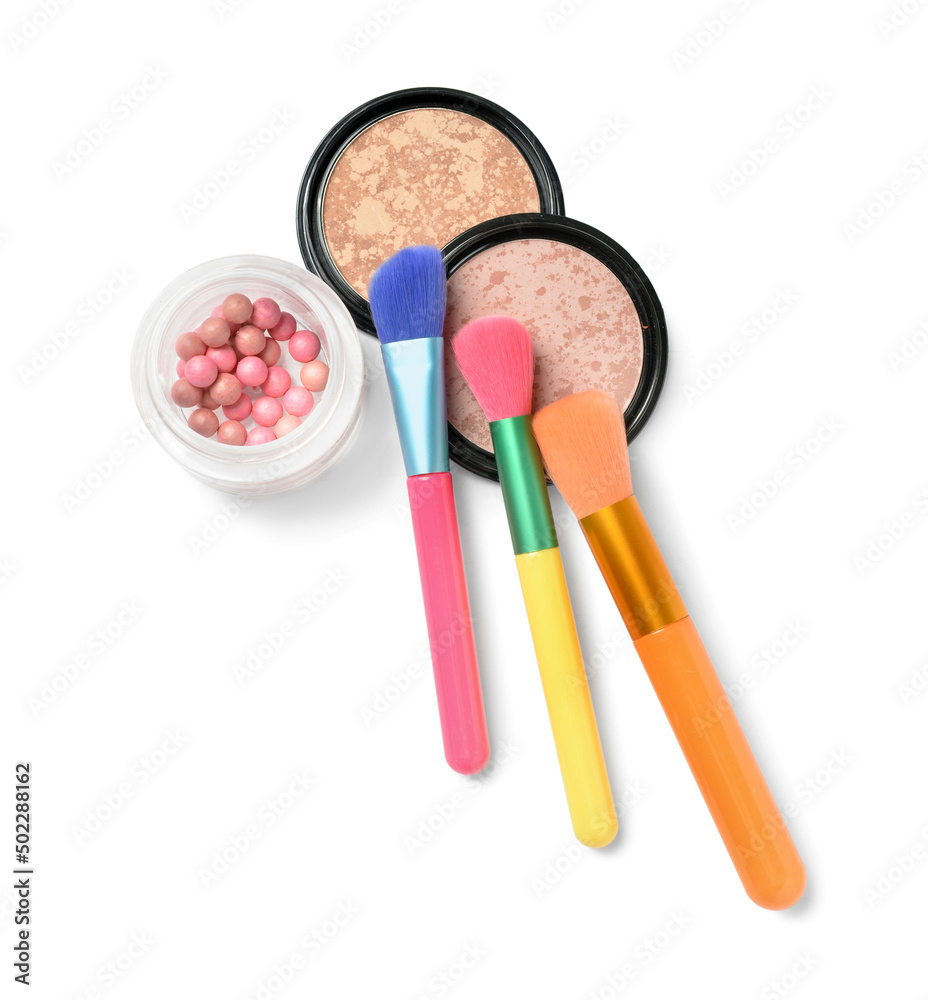 Colorful makeup brushes with highlighter on white background