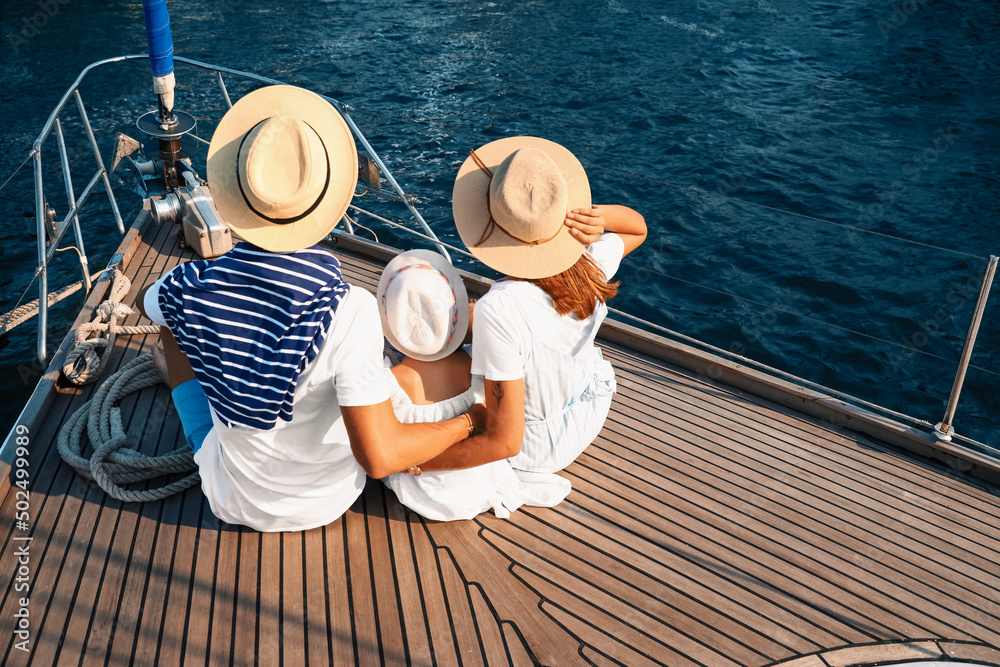 Happy young family resting on yacht