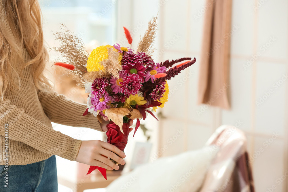 Woman with beautiful autumn bouquet indoors, closeup