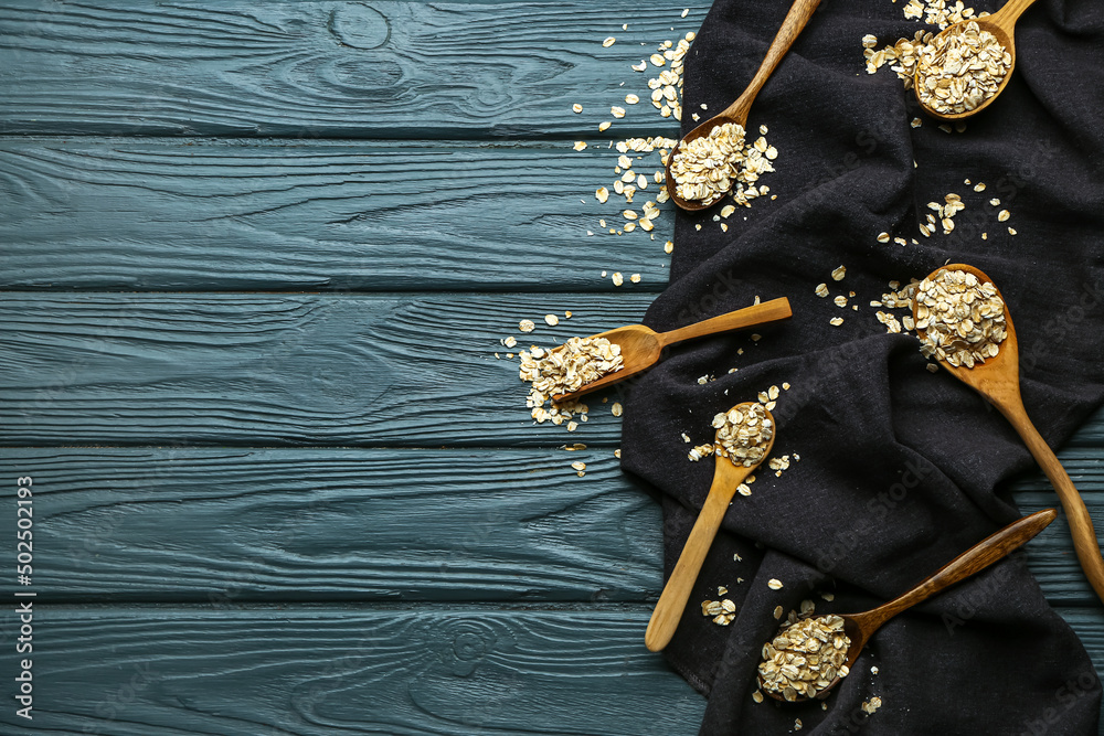 Composition with different spoons of raw oatmeal on dark wooden background