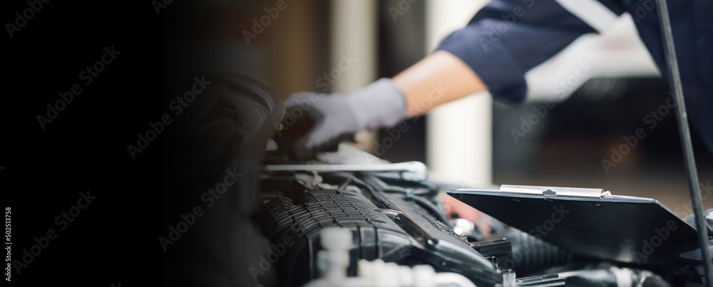 Car service, repair, maintenance concept,auto mechanic man or Smith writing to the clipboard at work