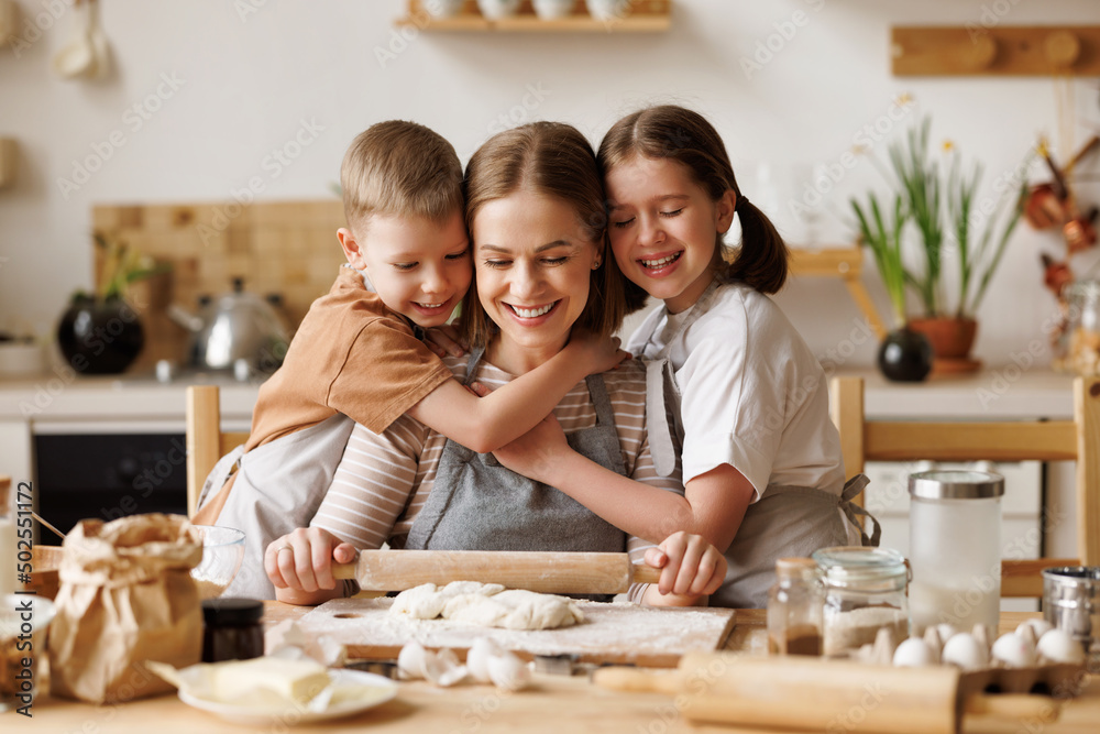 Positive family loving mother and cute children cooking together