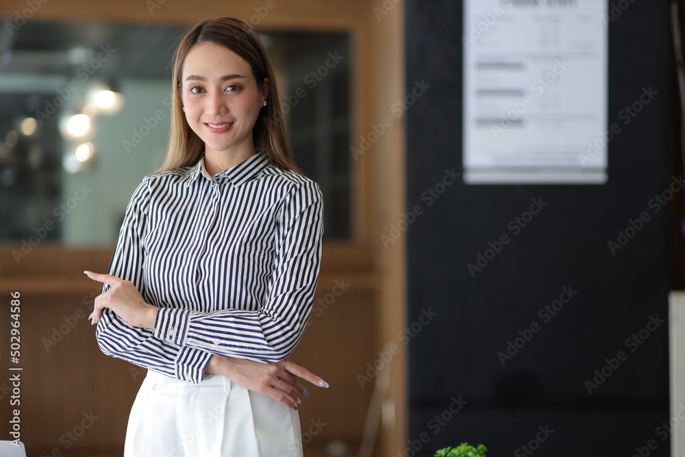 一位迷人的亚洲女商人或经理在办公室办公桌前的肖像。漂亮的秘书