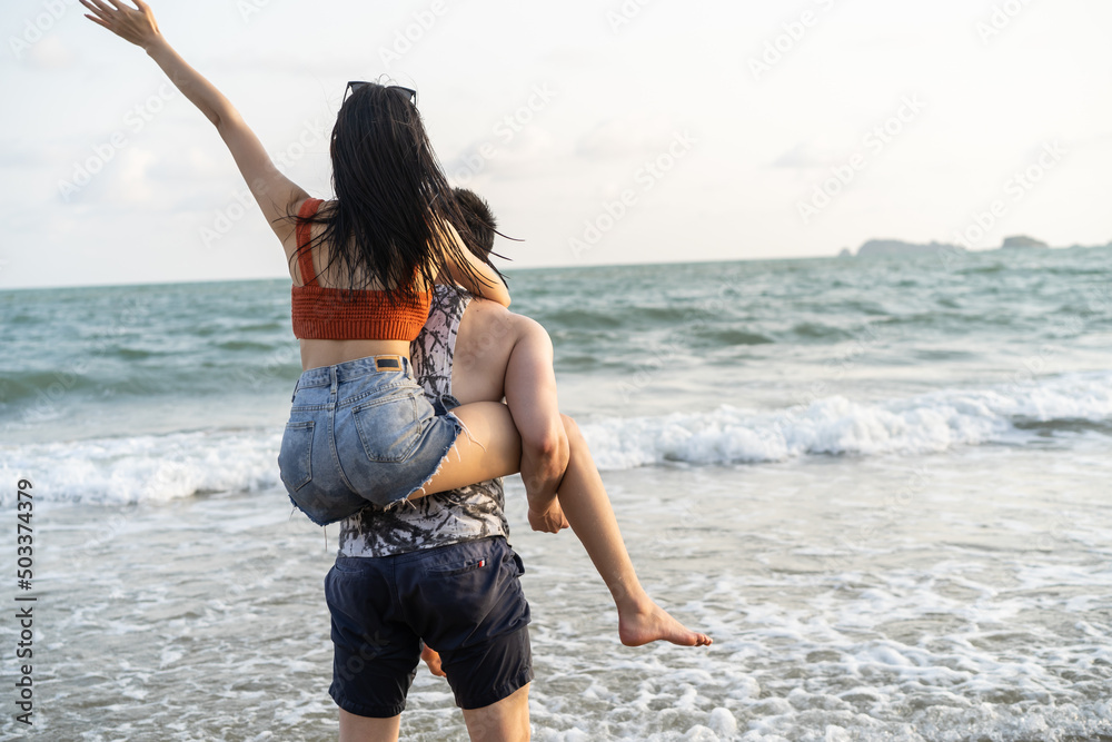 亚洲年轻男女一起在海滩上玩得很开心。